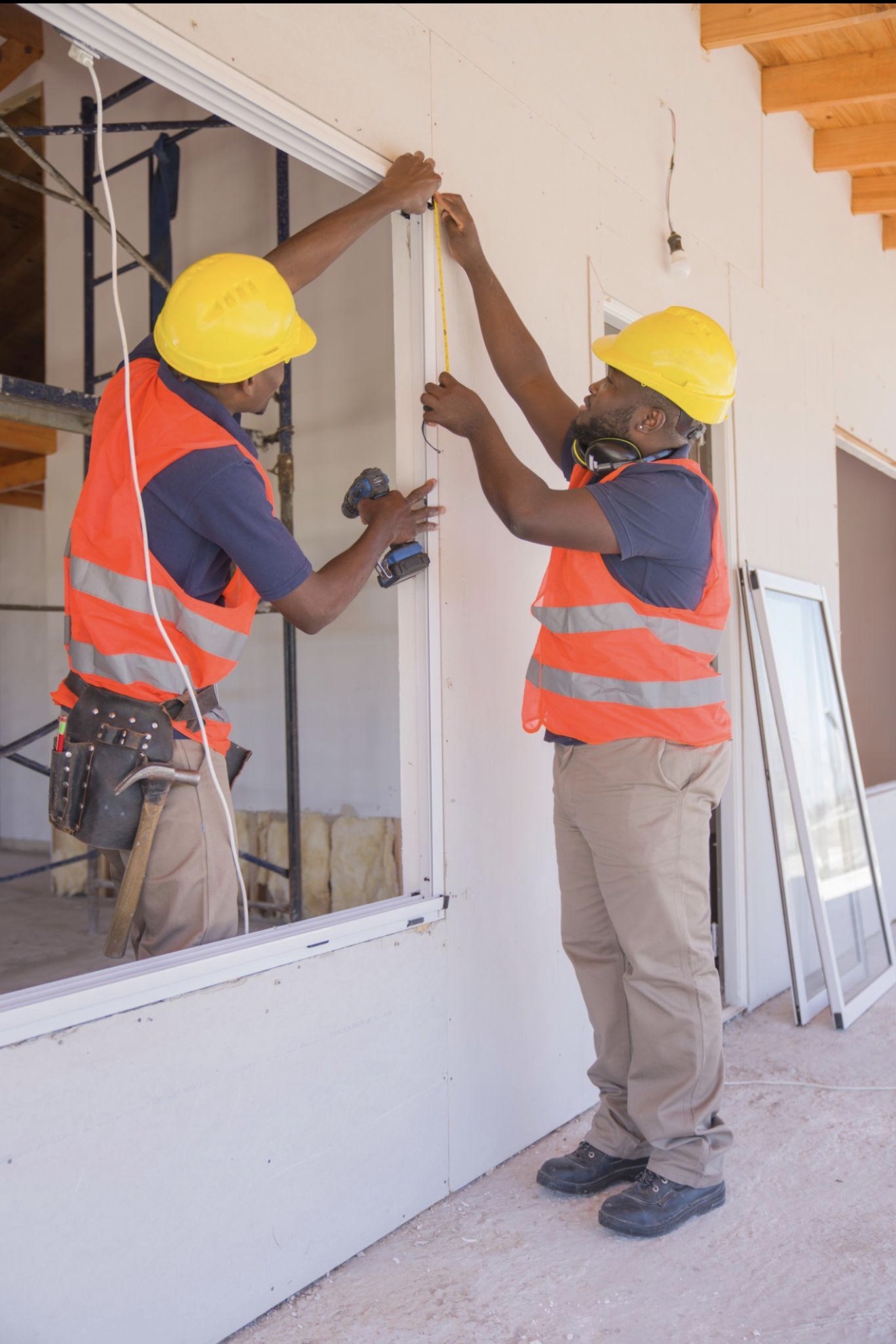 Contractors measuring and installing windows for weatherization